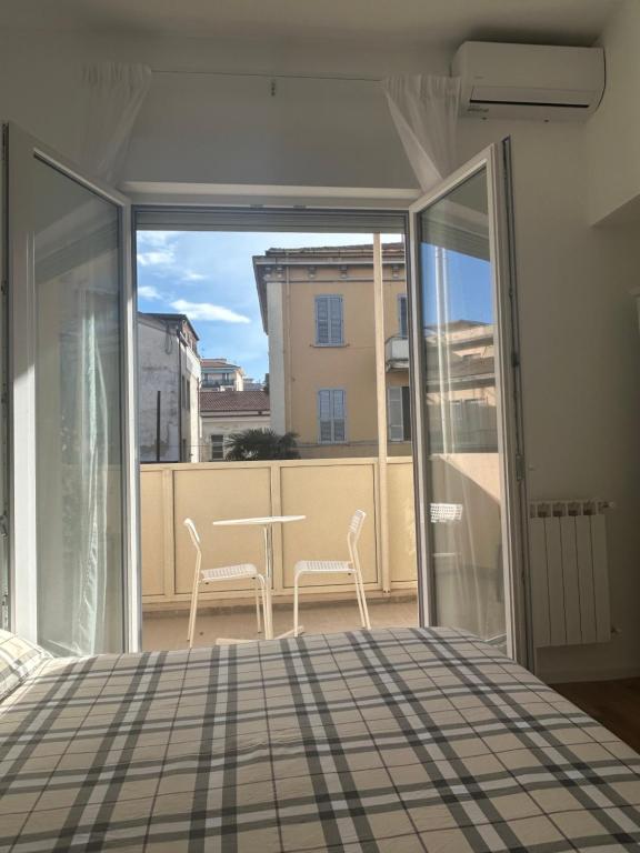 Porta finestra aperta sul balcone, con tavolino e due sedie