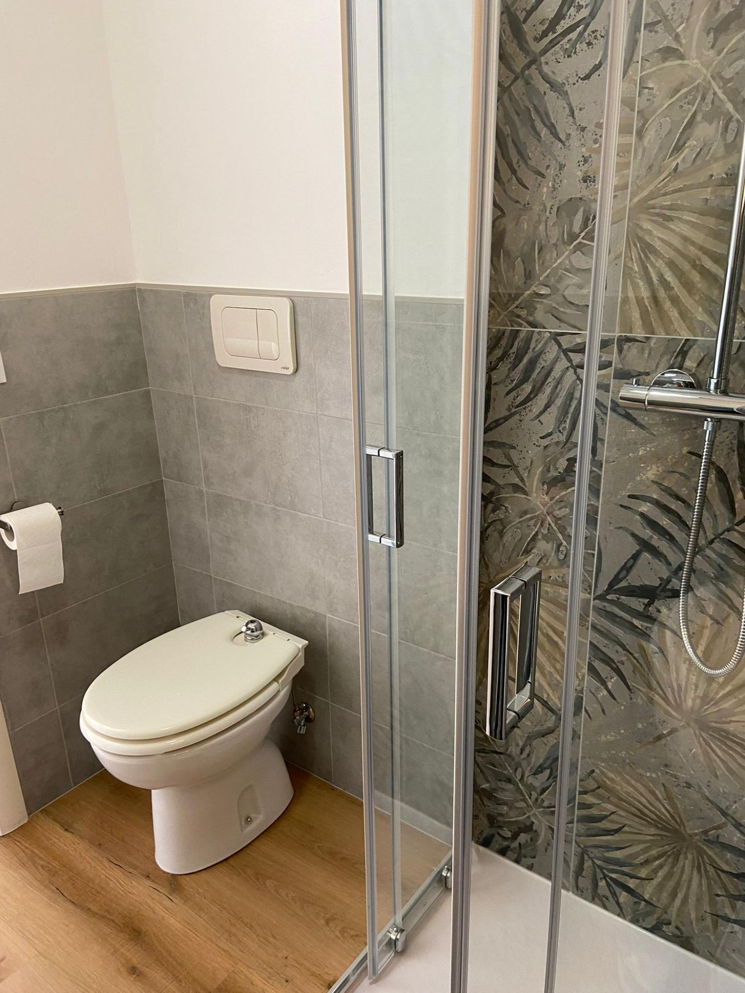Bagno privato con doccia e rivestimento in gres